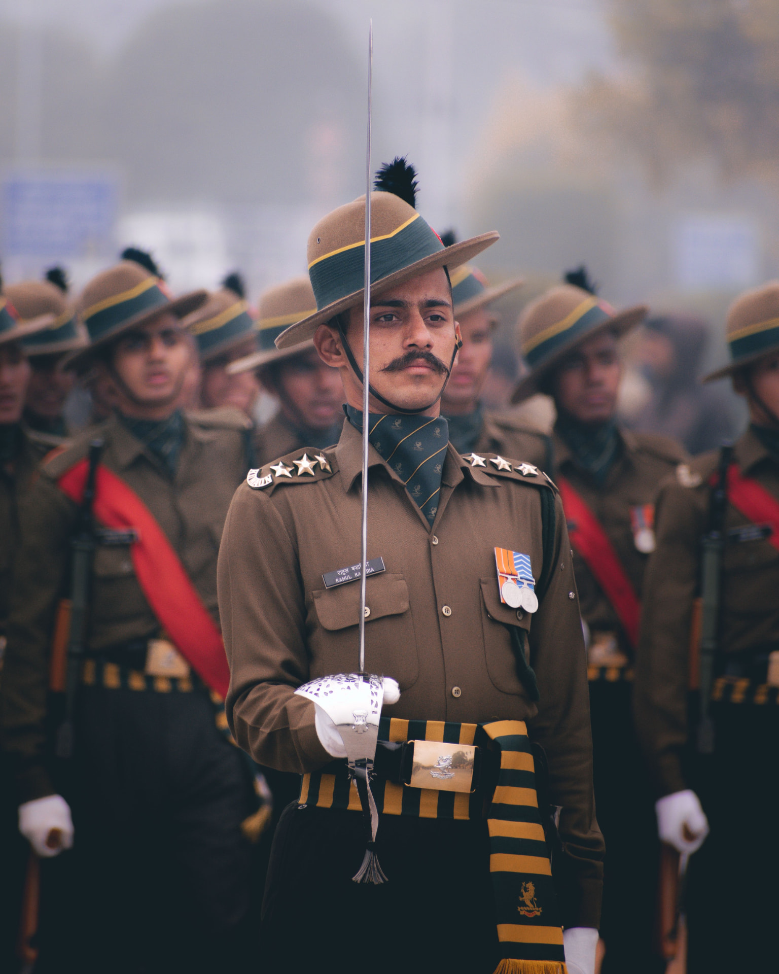 Indian Army officer leading a parade formation with a drawn sword at dawn